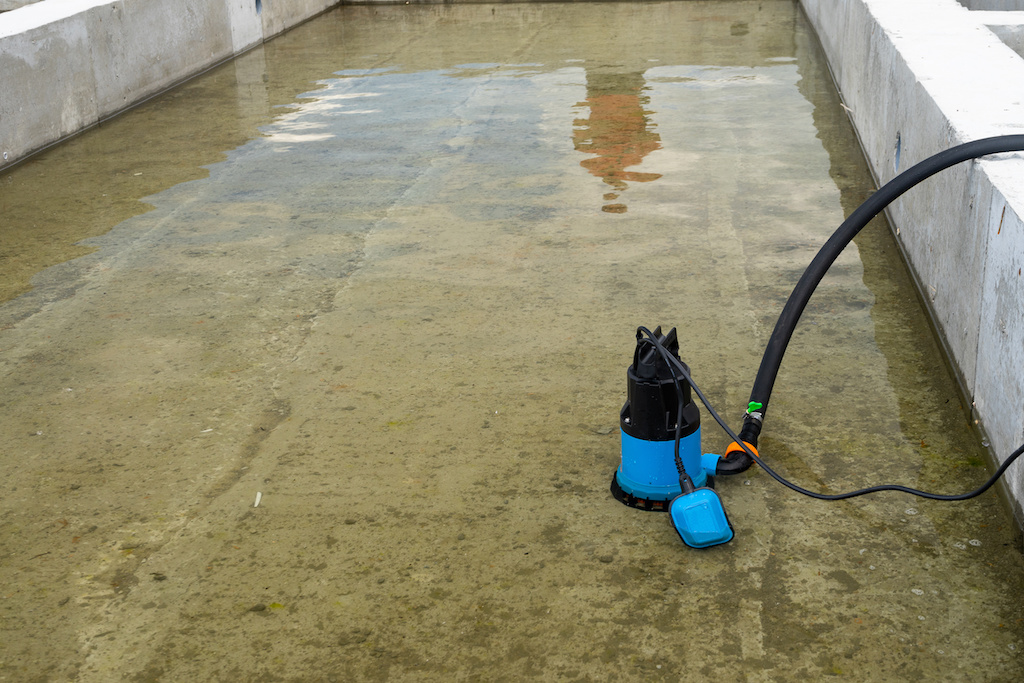 Submersible pump dewater construction site, pumping flood water sing deep well.